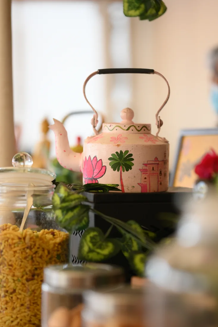 Hand-painted chai kettle with snack jars at the counter